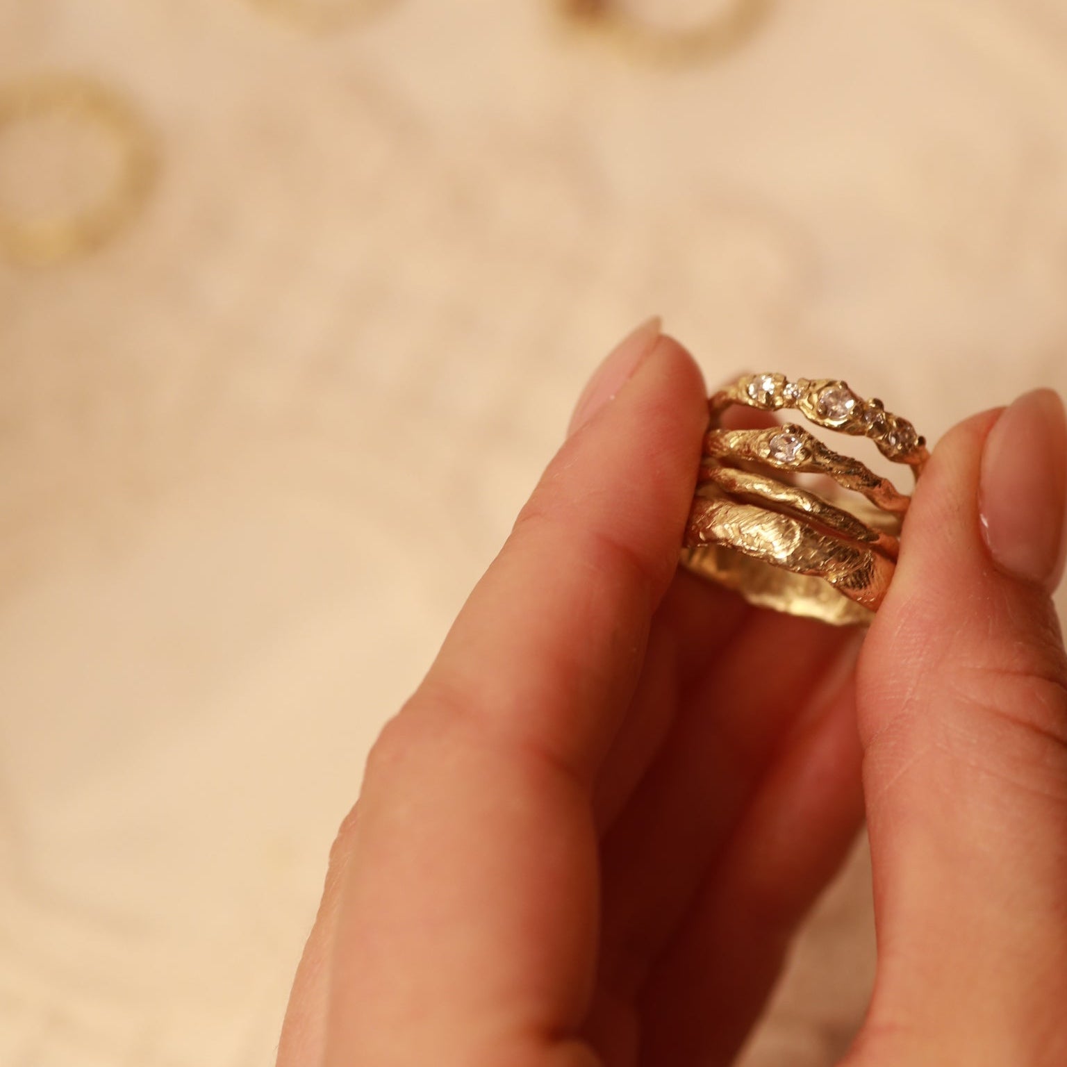 Hand holding a gold ring with a blurred background