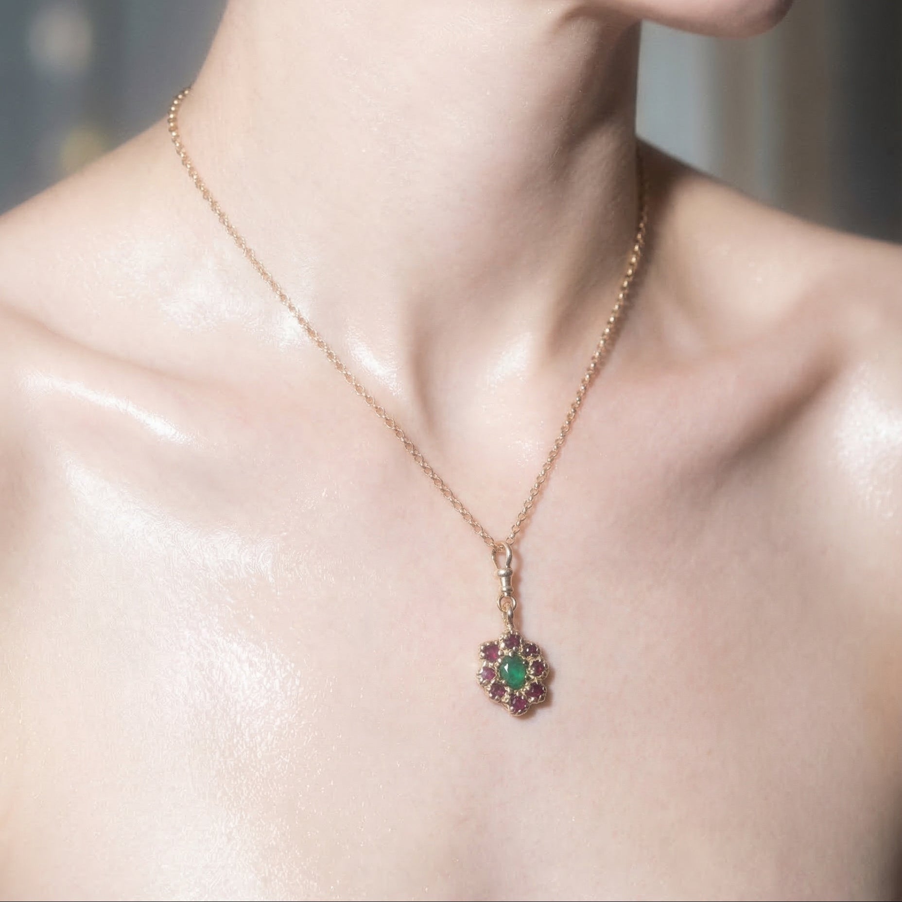 9ct yellow gold charm necklace, victorian inspired, with central emerald and surrounding rubies on model