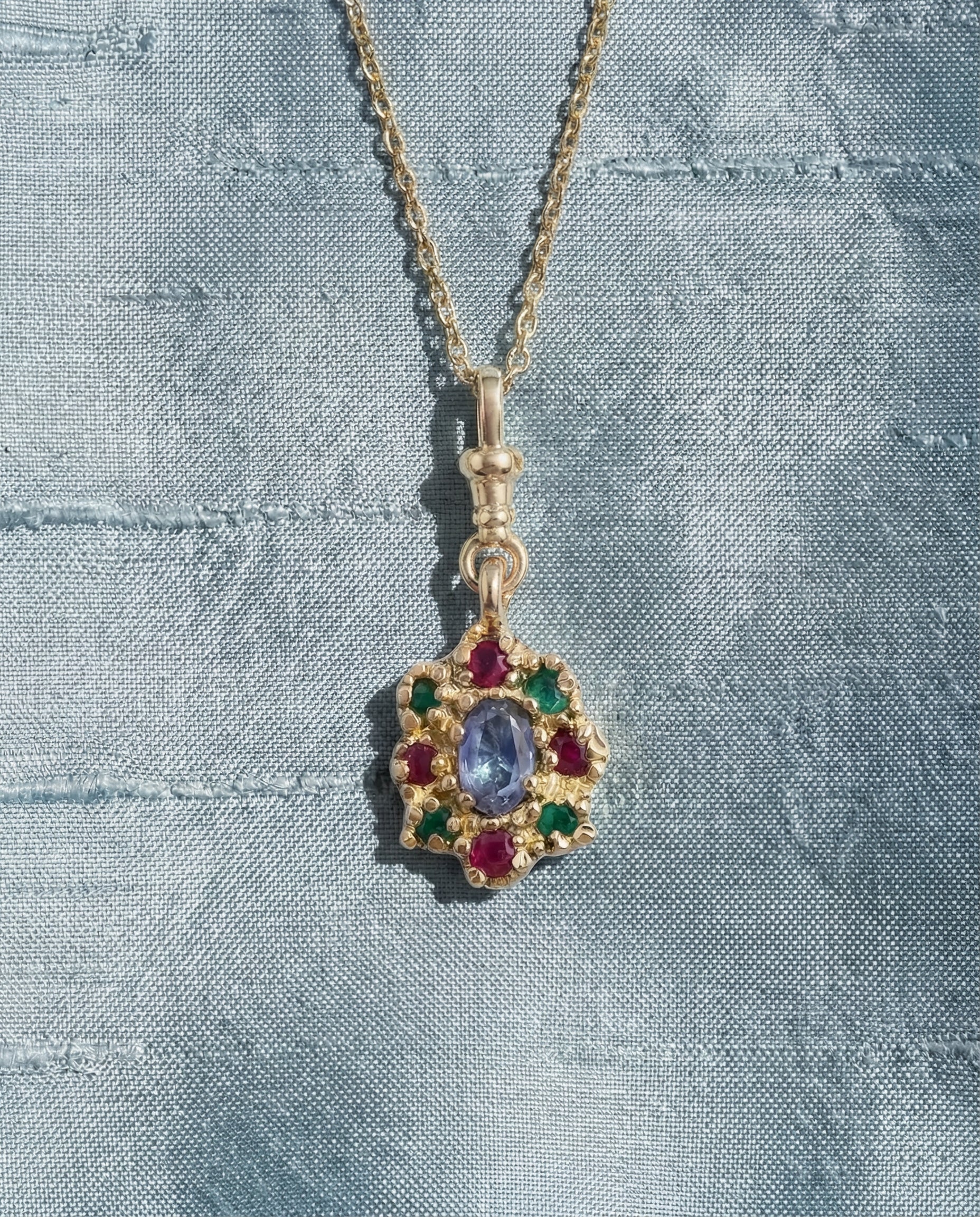 9ct yellow gold charm necklace, victorian inspired, set with central sapphire and surrounding rubies and emeralds on fabric