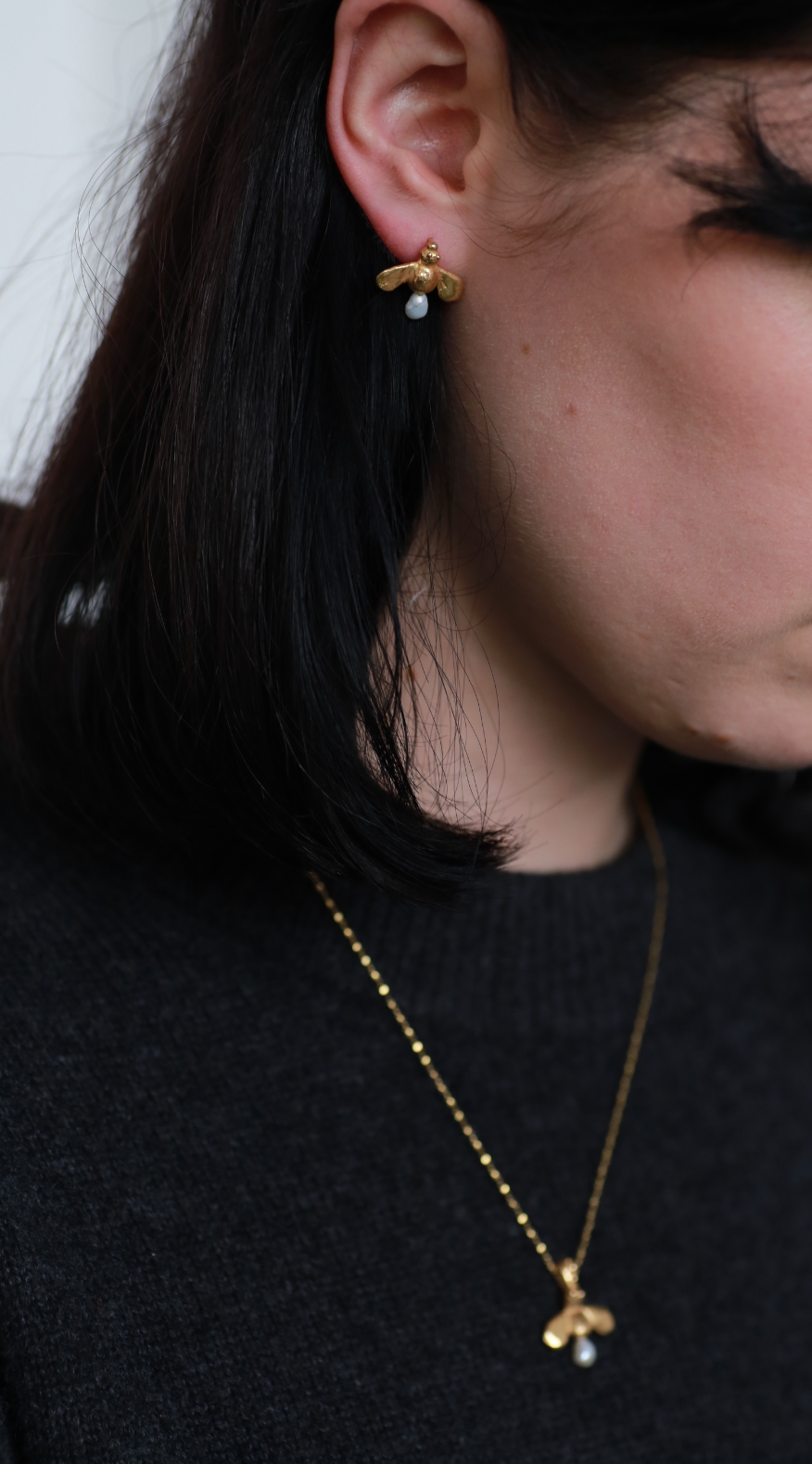 model wears the honey drop stud earrings and the queen bee necklace in gold vermeil