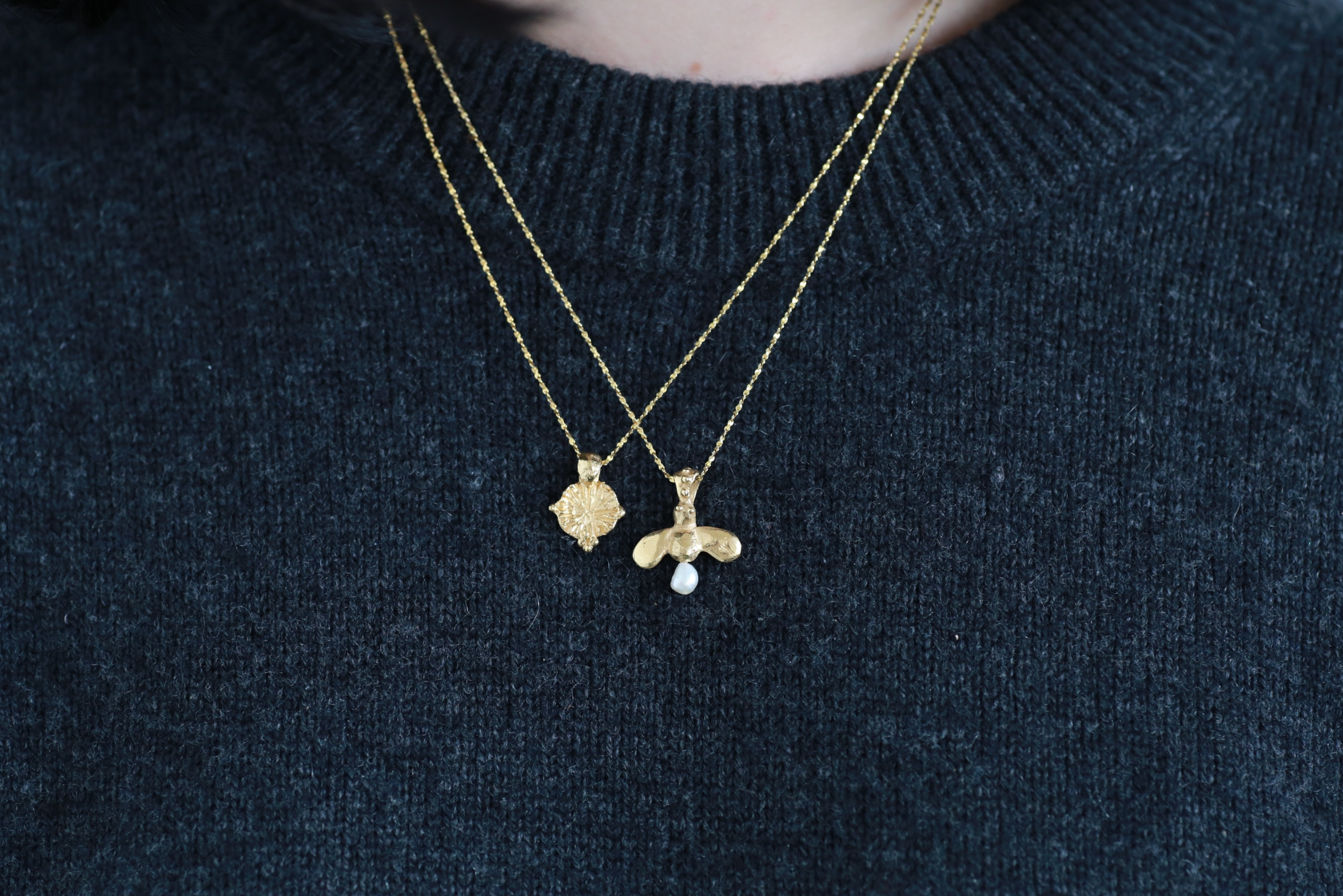 model wears the forget me not amulet and the queen bee necklace in gold vermeil